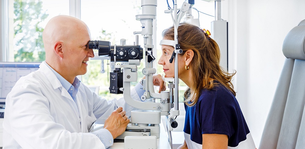 Der Augenarzt von Spital Zollikerberg misst die Sehschärfe von einer Patientin.